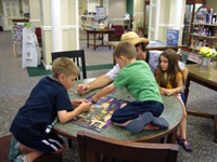 Tommy, Nicholas, Todd and O'Rosie finishing a jigsaw puzzle at the library.